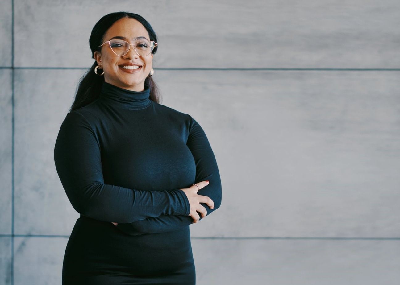 A smiling MBA holder with arms crossed.